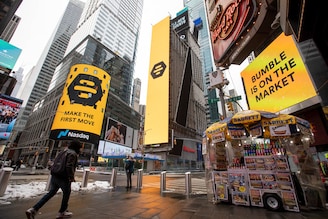 Monitors display Bumble Inc. signage during the company"s initial public offering (IPO) in front of the Nasdaq MarketSite in New York, U.S., on Thursday, February 11, 2021. Bumble Inc., the dating app where women make the first move, is targeting to raise as much as $1.8 billion from its U.S. initial public offering after boosting the size of the deal.