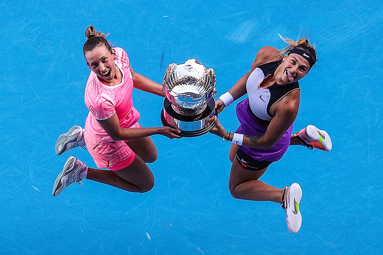 Belgium"s Elise Mertens (L) and partner Belarus" Aryna Sabalenka pose with their winners" trophy after beating Czech Republic"s Barbora Krejcikova and Katerina Siniakova in their women"s doubles final match on day twelve of the Australian Open tennis tournament in Melbourne on February 19, 2021.