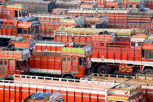 A man sits in the toolbox of his parked truck at a terminal during a nationwide strike to protest against rising fuel prices and the Goods and Services Tax (GST) rules, in Mumbai, India, February 26, 2021.