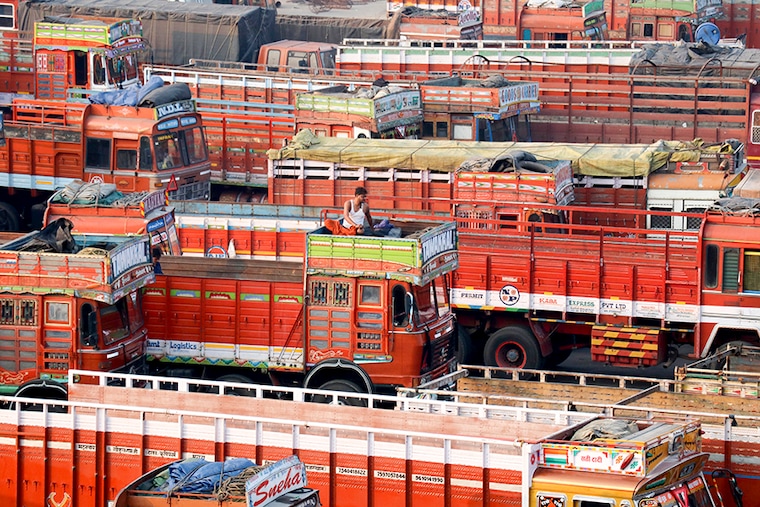 A man sits in the toolbox of his parked truck at a terminal during a nationwide strike to protest against rising fuel prices and the Goods and Services Tax (GST) rules, in Mumbai, India, February 26, 2021.