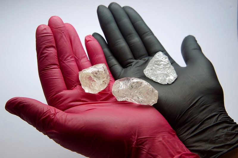 An employee shows gem-quality stones, including a rare 242-carat rough diamond that will be offered at the 100th international auction of Russian state-controlled diamond producer Alrosa, during a presentation in Moscow, Russia February 25, 2021. The diamond is one of the biggest gem-quality stones Alrosa has mined this century, the company said.
