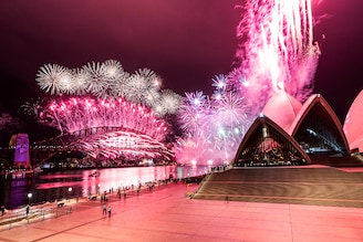 The Sydney Harbour fireworks display is seen over a near-empty Sydney Opera House forecourt during New Year"s Eve celebrations on January 01, 2021 in Sydney, Australia. Amidst a new outbreak of COVID-19 in Sydney, the normally 12-minute long midnight pyrotechnic display has been shortened to seven minutes. New COVID-19 restrictions are also in effect across NSW with household gatherings limited to five guests in greater Sydney, Wollongong, the Central Coast and Blue Mountains. Sydney"s Northern Beaches remain in lockdown as health authorities work to contain current coronavirus cluster outbreaks in the community.