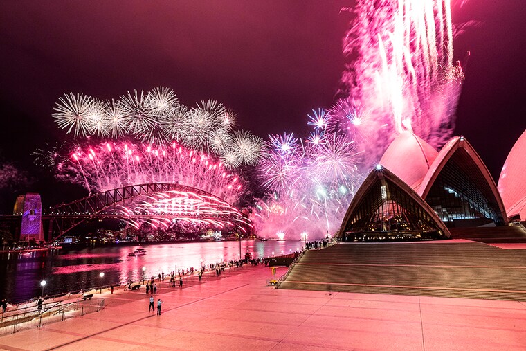The Sydney Harbour fireworks display is seen over a near-empty Sydney Opera House forecourt during New Year"s Eve celebrations on January 01, 2021 in Sydney, Australia. Amidst a new outbreak of COVID-19 in Sydney, the normally 12-minute long midnight pyrotechnic display has been shortened to seven minutes. New COVID-19 restrictions are also in effect across NSW with household gatherings limited to five guests in greater Sydney, Wollongong, the Central Coast and Blue Mountains. Sydney"s Northern Beaches remain in lockdown as health authorities work to contain current coronavirus cluster outbreaks in the community.