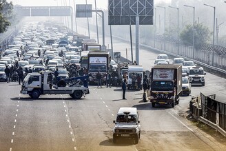 Traffic on NH48 is stopped momentarily as a temperature controlled truck carrying the Covid-19 vaccine is escorted by police on January 12, 2021 in New Delhi, India. The first batch of Covishield vaccine was delivered today in 13 Indian cities including Delhi, UP, Bihar Assam, Karnataka and Tamil Nadu by air as the country is set to launch a massive vaccination drive on January 16. As many as 1.3 billion people of the country are likely to get vaccinated during the drive, which officials described as the worlds biggest inoculation drive to fight against coronavirus that created havoc across the globe.