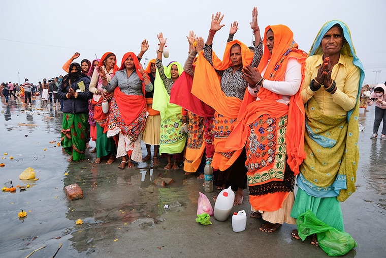 Pilgrims are praying to the river Ganges after having the holy bath during Makar Sankranti on the beach, a confluence of the Ganges and the sea. They believe the holy bath during Sankranti will lead them towards heaven after death.