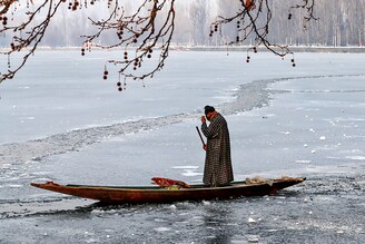 A man rows his boat on the partially frozen Dal Lake in Srinagar January 14, 2021. Across the Kashmir Valley and in the Srinagar mercury settling at minus 8.4°C, the lowest temperature of this winter so far and the coldest January nights in the last three decades.
