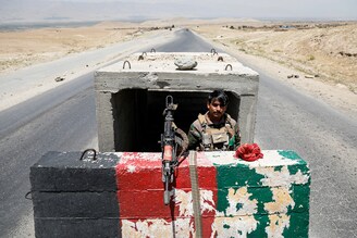 A lone Afghan National Army soldier stands guard at a checkpoint near Bagram U.S. air base, on the day the last of American and Nato troops vacated it amid Taliban surge, Parwan province, Afghanistan July 2, 2021. In the districts captured by the surging Taliban, violently ultra-conservative laws are returning, reviving dark memories of the 90s.
