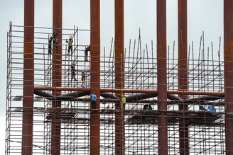 Workers aloft on scaffoldings at a construction site in Mumbai on July 5, 2021. Developers are getting workers vaccinated at construction sites, and in many cases, bearing the cost of the vaccination. The real estate sector contributes 14 percent to 15 percent to the Nation"s Gross Domestic Product (GDP), the second-highest after agriculture.