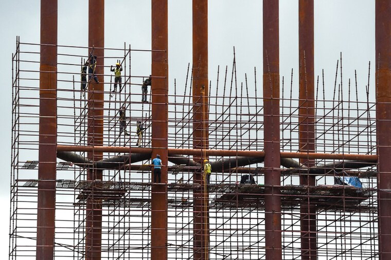 Workers aloft on scaffoldings at a construction site in Mumbai on July 5, 2021. Developers are getting workers vaccinated at construction sites, and in many cases, bearing the cost of the vaccination. The real estate sector contributes 14 percent to 15 percent to the Nation"s Gross Domestic Product (GDP), the second-highest after agriculture.