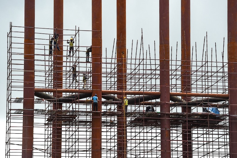 Workers aloft on scaffoldings at a construction site in Mumbai on July 5, 2021. Developers are getting workers vaccinated at construction sites, and in many cases, bearing the cost of the vaccination. The real estate sector contributes 14 percent to 15 percent to the Nation"s Gross Domestic Product (GDP), the second-highest after agriculture.