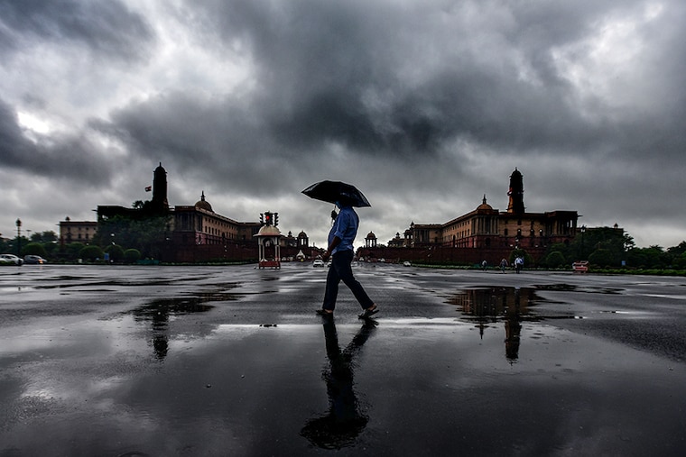 People enjoying rain shower at Vijay Chowk near North Block and South Block on July 14, 2021 in New Delhi, India. Rains lashed Delhi NCR for the second consecutive day on Wednesday, leading to heavy waterlogging on major roads and low-lying residential areas, and disrupting traffic for long hours. The maximum temperature settled at 35 degrees Celsius, normal for this time of the year.