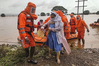 India"s National Disaster Response Force (NDRF) personnel rescue stranded villagers from flooded areas following heavy monsoon rains in Balinge village, Kolhapur district, Maharashtra, July 25, 2021. Over 1.4 lakh people have been evacuated and over 1.5 lakh hectares of farm land and crops are reportedly damaged across the state.
