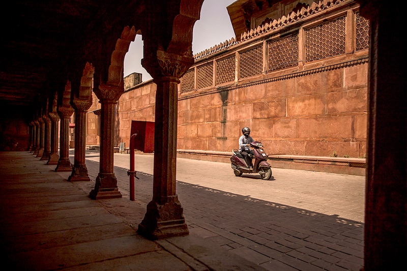 A motorcyclist rides along a deserted street near one of the entry gates to the Taj Mahal during lockdown restrictions in Agra, Uttar Pradesh on June 6, 2021. Indian consumers" confidence is plunging to new lows, adding to a string of grim economic data amid the second wave of the coronavirus. However, in some relief, several states, including New Delhi and Maharashtra have started relaxing lockdown norms as cases come down