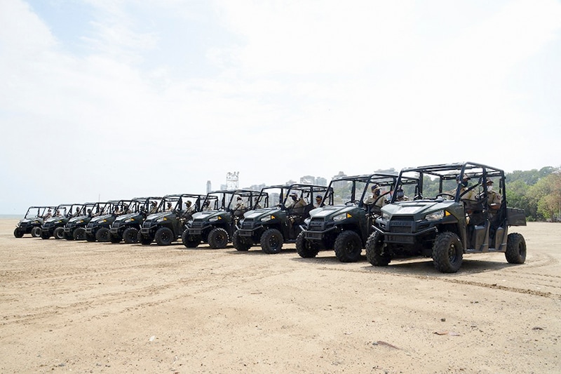 Police personnel sit on their all-terrain vehicle (ATV) used to patrol beaches at Girgaon Chowpatty beach in Mumbai on June 7, 2021.