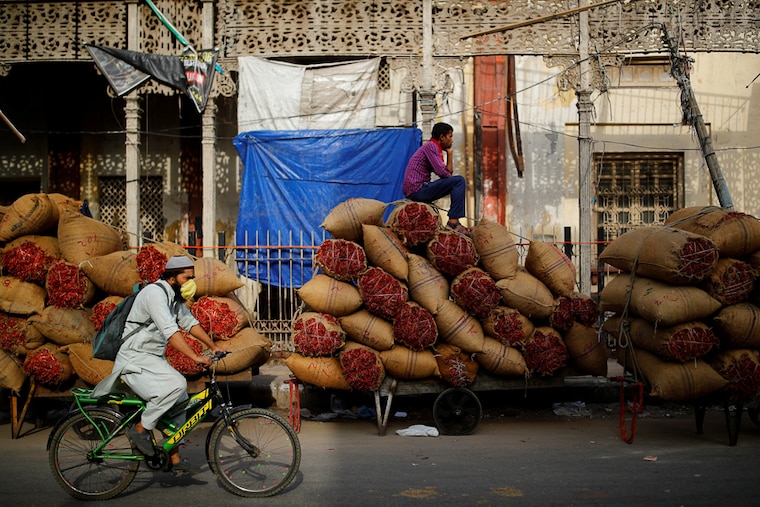 A worker perches on cartloads of spices at a bustling wholesale market in Delhi"s old quarters after authorities eased lockdown restrictions that were imposed to slow the spread of Covid-19 virus. June 8, 2021