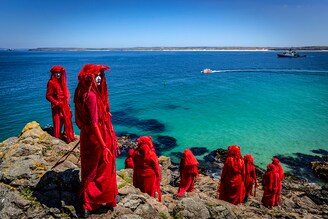 The Red Rebel Brigade which is part of the Extinction Rebellion movement pose on St Ives Head. The Environmental Protest Groups gather in Cornwall as the UK Prime Minister, Boris Johnson, hosts leaders from the USA, Japan, Germany, France, Italy and Canada at the G7 Summit in Carbis Bay. Protest groups hope to highlight their various causes to the G7 leaders and a global audience as the eyes of the world focus on Cornwall during the summit.
