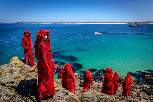 The Red Rebel Brigade which is part of the Extinction Rebellion movement pose on St Ives Head. The Environmental Protest Groups gather in Cornwall as the UK Prime Minister, Boris Johnson, hosts leaders from the USA, Japan, Germany, France, Italy and Canada at the G7 Summit in Carbis Bay. Protest groups hope to highlight their various causes to the G7 leaders and a global audience as the eyes of the world focus on Cornwall during the summit.