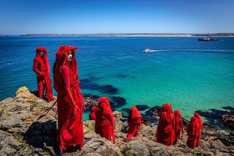 The Red Rebel Brigade which is part of the Extinction Rebellion movement pose on St Ives Head. The Environmental Protest Groups gather in Cornwall as the UK Prime Minister, Boris Johnson, hosts leaders from the USA, Japan, Germany, France, Italy and Canada at the G7 Summit in Carbis Bay. Protest groups hope to highlight their various causes to the G7 leaders and a global audience as the eyes of the world focus on Cornwall during the summit.