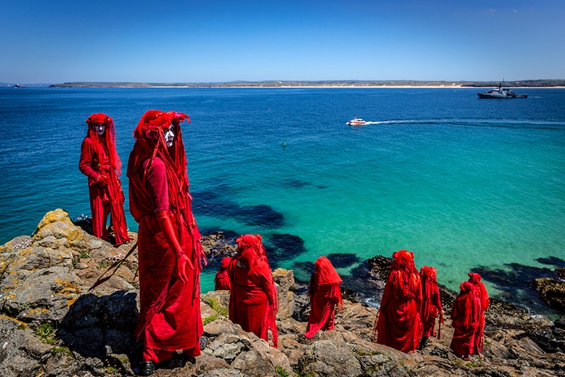 The Red Rebel Brigade which is part of the Extinction Rebellion movement pose on St Ives Head. The Environmental Protest Groups gather in Cornwall as the UK Prime Minister, Boris Johnson, hosts leaders from the USA, Japan, Germany, France, Italy and Canada at the G7 Summit in Carbis Bay. Protest groups hope to highlight their various causes to the G7 leaders and a global audience as the eyes of the world focus on Cornwall during the summit.