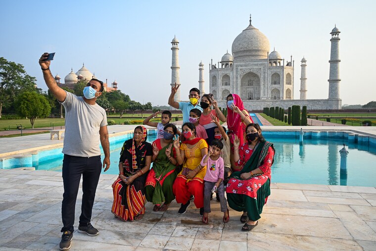 A family takes a souvenir photo at the Taj Mahal, one of the great wonders of the world, after monuments were reopened to visitors following the easing of Covid-19 restrictions in Agra on June 16, 2021. Uttar Pradesh saw its tourism numbers crashing by 84 percent in 2020, with its top tourism sites like the Taj Mahal staying closed for much of the year.