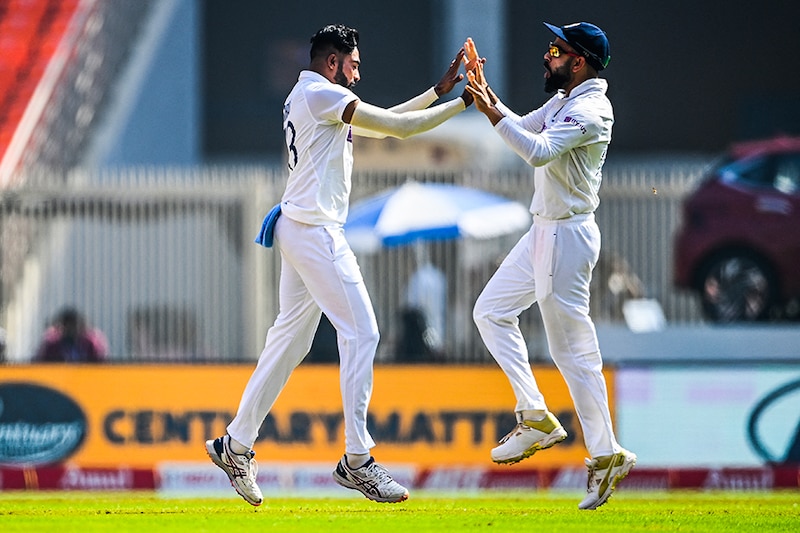 India"s Mohammed Siraj (L) celebrates with team captain Virat Kohli after dismissing England"s captain Joe Root (not pictured) during the first day of the fourth Test cricket match between India and England at the Narendra Modi Stadium in Motera on March 4, 2021.