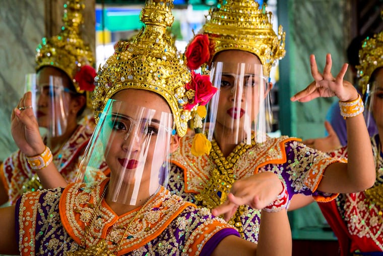 Traditional Thai dancers wearing protective face shields against the spread of the Covid-19 coronavirus perform at the Erawan Shrine in Bangkok on March 12, 2021.