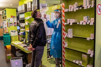 Customer Johann Maurer gets a nasal swab taken by pharmacist Josefine Wiecha for a free Corona quick test at a pharmacy in the city centre. Bavaria"s pharmacies can now offer free Corona quick tests for citizens without cold symptoms.