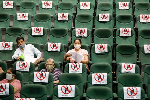 People sit under observation after receiving a dose of COVISHIELD, the coronavirus disease (COVID-19) vaccine manufactured by Serum Institute of India, at an auditorium, which has been converted into a temporary vaccination centre in Ahmedabad, India, March 16, 2021.