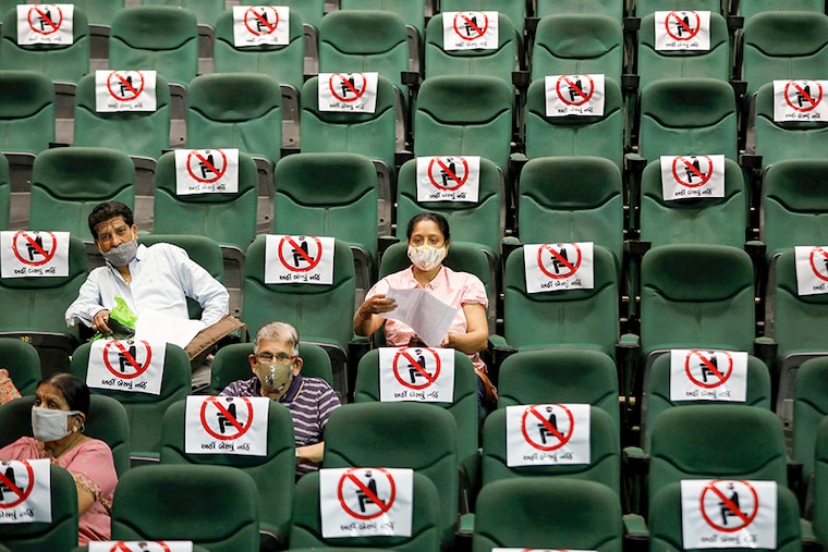 People sit under observation after receiving a dose of COVISHIELD, the coronavirus disease (COVID-19) vaccine manufactured by Serum Institute of India, at an auditorium, which has been converted into a temporary vaccination centre in Ahmedabad, India, March 16, 2021.