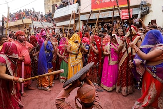 Women of Barsana rain playful blows on their menfolk during Lathmar Holi celebrations in the town of Barsana, northern state of Uttar Pradesh, India, March 23, 2021. Authorities have cautioned the public against congregating in festivals like these in the midst of a second wave of COVID-19 in various parts of India