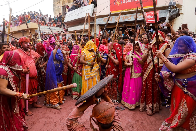 Women of Barsana rain playful blows on their menfolk during Lathmar Holi celebrations in the town of Barsana, northern state of Uttar Pradesh, India, March 23, 2021. Authorities have cautioned the public against congregating in festivals like these in the midst of a second wave of COVID-19 in various parts of India