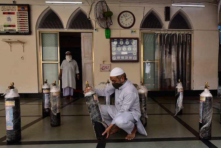A volunteer checks oxygen cylinders before being distributed for free to the needy at Khokha Masjid, Nagdevi Street, on May 6, 2021, in Mumbai, India.