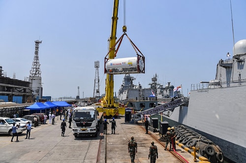Navy personnel unload Liquid Medical Oxygen (LMO) tanks supplied by French company Air Liquide as part of France"s assistance efforts toward Covid-19 coronavirus relief to India after arriving from Qatar, at the naval dockyard in Mumbai on May 10, 2021.