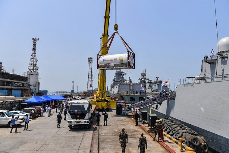 Navy personnel unload Liquid Medical Oxygen (LMO) tanks supplied by French company Air Liquide as part of France"s assistance efforts toward Covid-19 coronavirus relief to India after arriving from Qatar, at the naval dockyard in Mumbai on May 10, 2021.