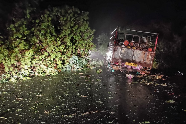 A truck loaded with oxygen cylinders is stuck by fallen trees from the impact of cyclone Tauktae, near Mahuva in Gujarat state. The powerful cyclone made landfall in Western India on the night of May 17, with heavy rains and strong winds battering the region, forcing officials to evacuate thousands of people including Covid-19 patients from hospitals near the coast.