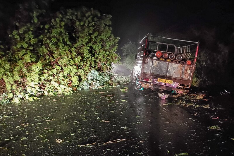 A truck loaded with oxygen cylinders is stuck by fallen trees from the impact of cyclone Tauktae, near Mahuva in Gujarat state. The powerful cyclone made landfall in Western India on the night of May 17, with heavy rains and strong winds battering the region, forcing officials to evacuate thousands of people including Covid-19 patients from hospitals near the coast.