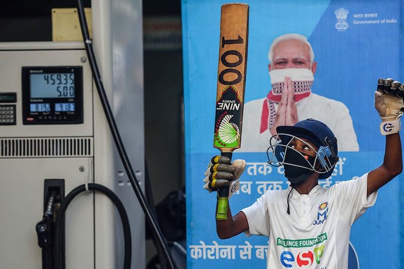 A cricket fan poses for a photo at a petrol pump after petrol price touches Rs 100 in Thane and in Mumbai at Rs 99.94 per litre on May 27, 2021, in Mumbai, India.