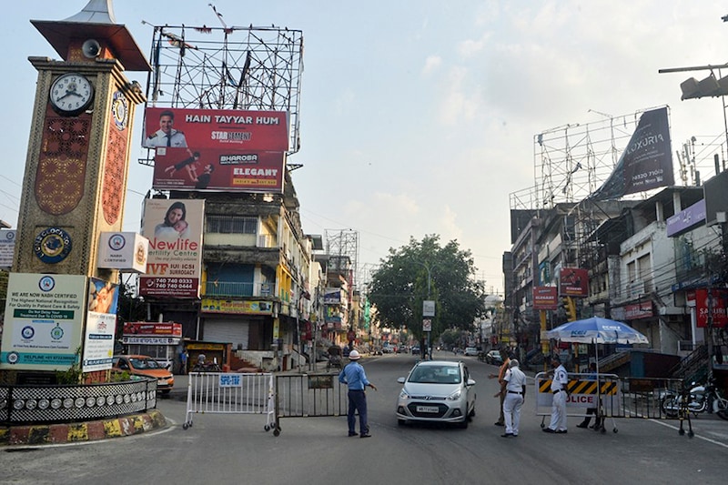 Police personnel stop vehicles at a road checkpoint during a lockdown in West Bengal state, which has been extended till June 15th, to curb the spread of Covid-19 coronavirus in Siliguri on May 29, 2021.