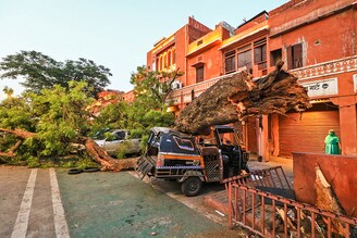 Vehicles damaged under an uprooted tree following a heavy storm at Kishanpole Bazar in Jaipur, Rajasthan, India, Sunday, May 30, 2021.