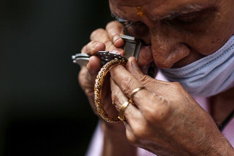 A goldsmith checks the diamonds inset in a gold bangle at Zaveri Bazaar during the festival of Dhanteras in Mumbai on Nov. 2, 2021. A festive cheer lit up India"s gold sales as Indians flocked to jewellery stores for the first time since the pandemic began"‹, on the biggest gold-buying day of the year.