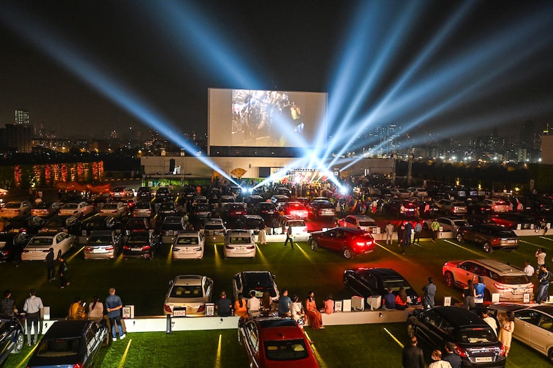 People watch a movie from their cars during a premiere screening at Jio Drive-in, India"s first open air rooftop drive-in cinema in Mumbai on November 5, 2021. The Reliance Retail and PVR venture, which can accommodate around 290 vehicles, opened with Akshay Kumar-fronted "Sooryavanshi" this Diwali weekend.