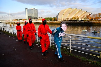 Climate activists dressed as characters inspired by the Netflix series "Squid Game" protest as they ask Samsung to go 100% renewable energy, outside the venue for the UN Climate Change Conference (COP26) in Glasgow, Scotland Britain, November 10, 2021.