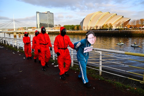 Climate activists dressed as characters inspired by the Netflix series "Squid Game" protest as they ask Samsung to go 100% renewable energy, outside the venue for the UN Climate Change Conference (COP26) in Glasgow, Scotland Britain, November 10, 2021.