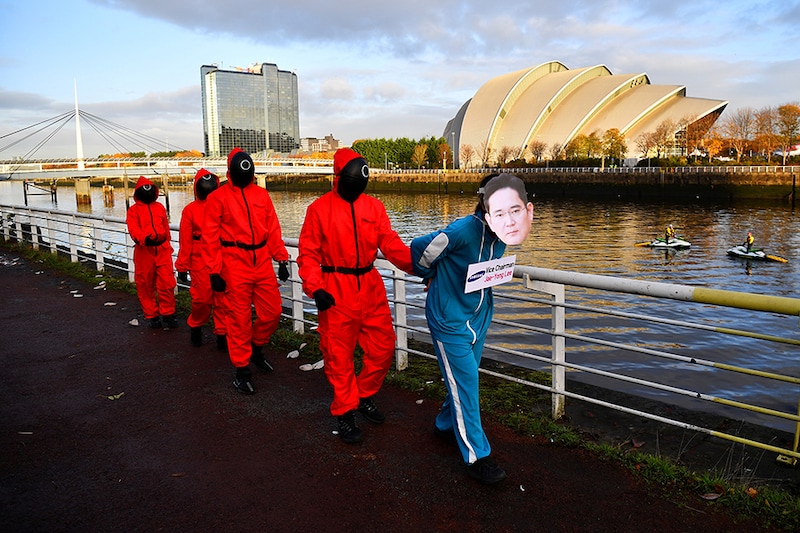 Climate activists dressed as characters inspired by the Netflix series "Squid Game" protest as they ask Samsung to go 100% renewable energy, outside the venue for the UN Climate Change Conference (COP26) in Glasgow, Scotland Britain, November 10, 2021.