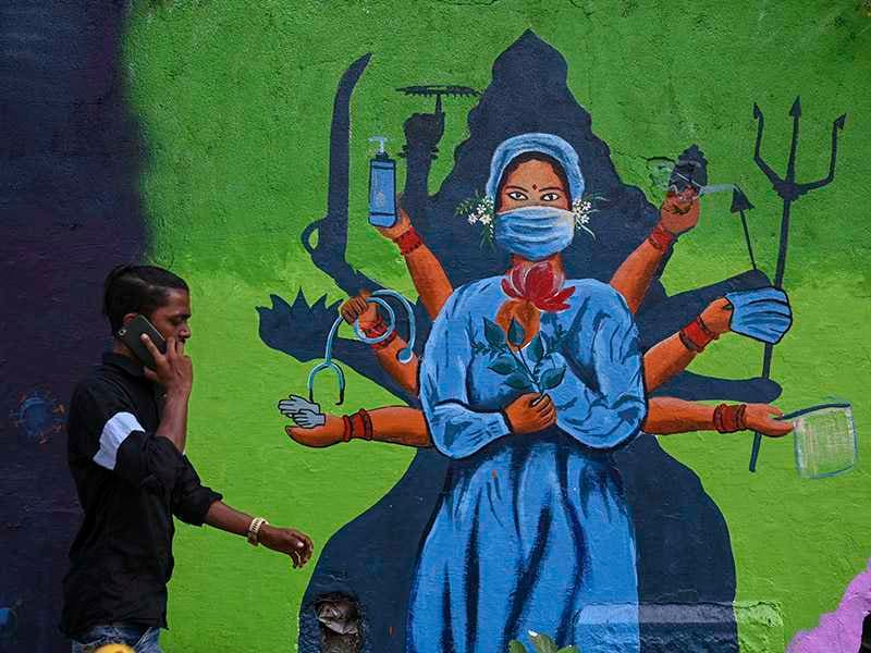 A man walks past a wall mural depicting a healthcare worker as the Goddess Durga to spread awareness about the Covid-19 coronavirus in Mumbai on November 17, 2021.