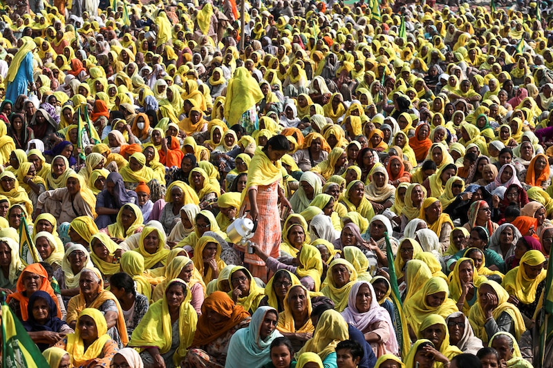 A woman serves water at the gathering by farmers and members of farming households to celebrate the first anniversary of their protests against the three farm laws that the government has agreed to formally withdraw, Tikri border, November 26, 2021. The farmers plan to continue the agitation till the government agrees to their other demands, including the legal guarantee for the minimum support price (MSP).