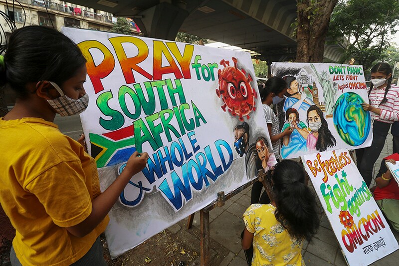 Students apply finishing touches to paintings made to create an awareness against the new coronavirus Omicron variant, in Mumbai, India, November 29, 2021.