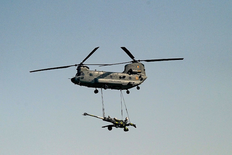 An Indian Air Force (IAF) Chinook helicopter flypast carrying an artillery gun during the 89th Air Force Day parade at Hindon Air Force Station in Ghaziabad on October 8, 2021.
