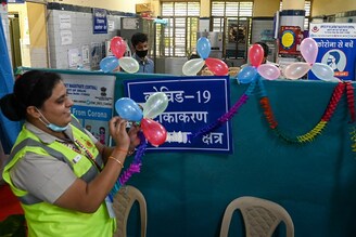 Volunteers decorate a vaccination centre to celebrate India administering its billionth Covid-19 vaccine against the coronavirus at a health centre in New Delhi on October 21, 2021. India administered the billionth Covid-19 vaccine dose on October 21, according to the health ministry, half a year after a devastating surge in cases brought the health system close to collapse.