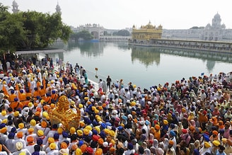 Sikh devotees carry the Guru Granth Sahib (Sikh holy book) in a palanquin during a religious procession on the eve of the birth anniversary of the fourth Sikh Guru Ram Das at the Golden Temple in Amritsar on October 21, 2021.